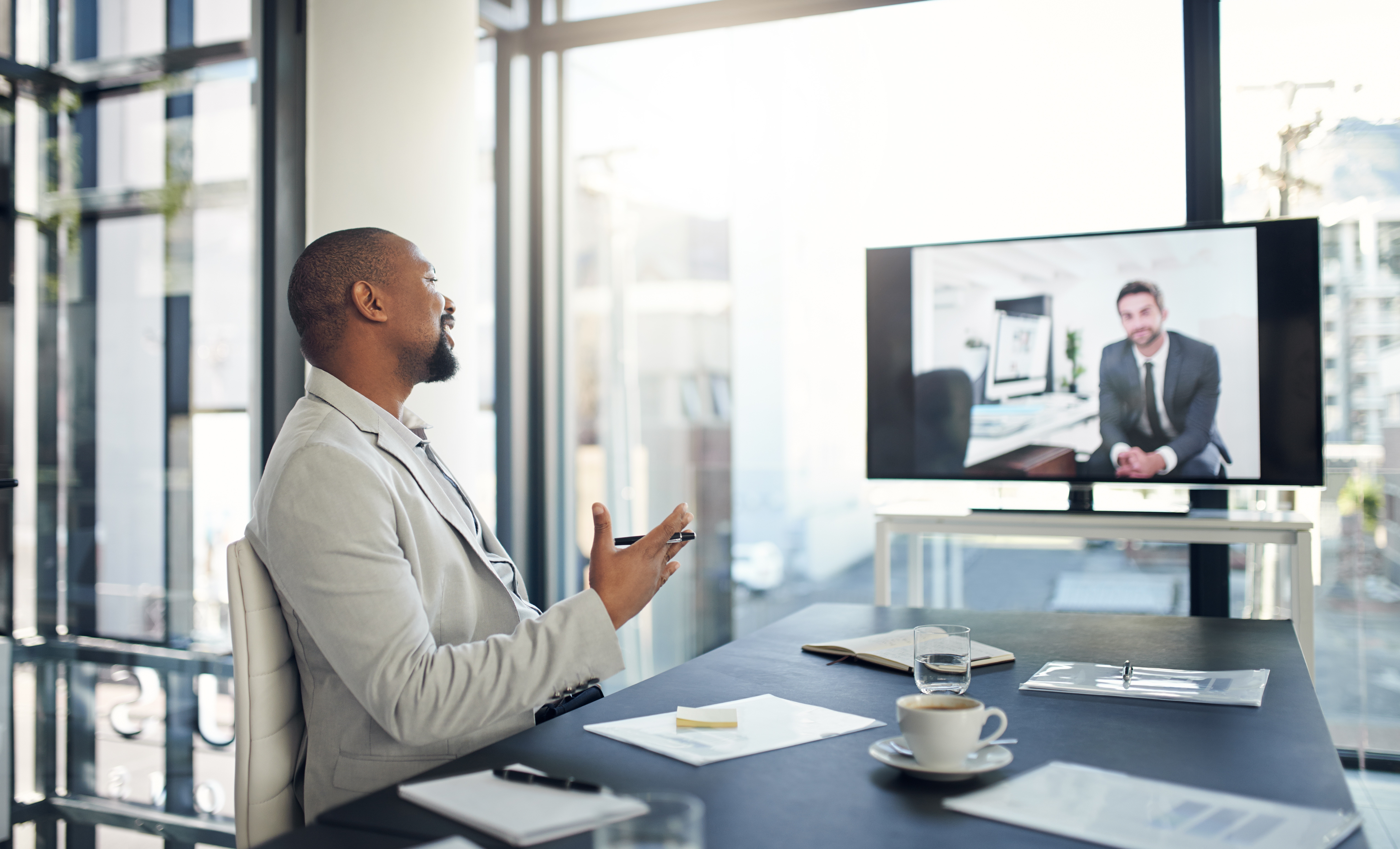A man in an office haveing a video conference call.